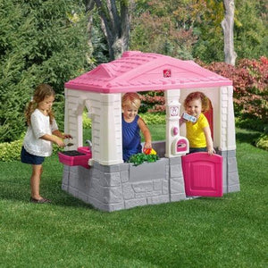 kinderen-spelen-in-speelhuisje-step2-neat-tidy-cottage-roze-kinderhuisje